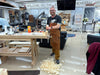 Man in a workshop with tools and materials on a table