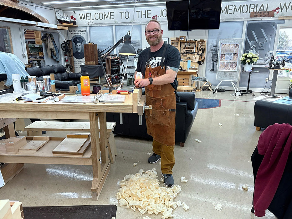 Man in a workshop with tools and materials on a table