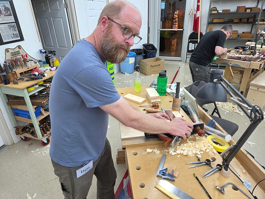 Man working on a project at a workbench in a workshop