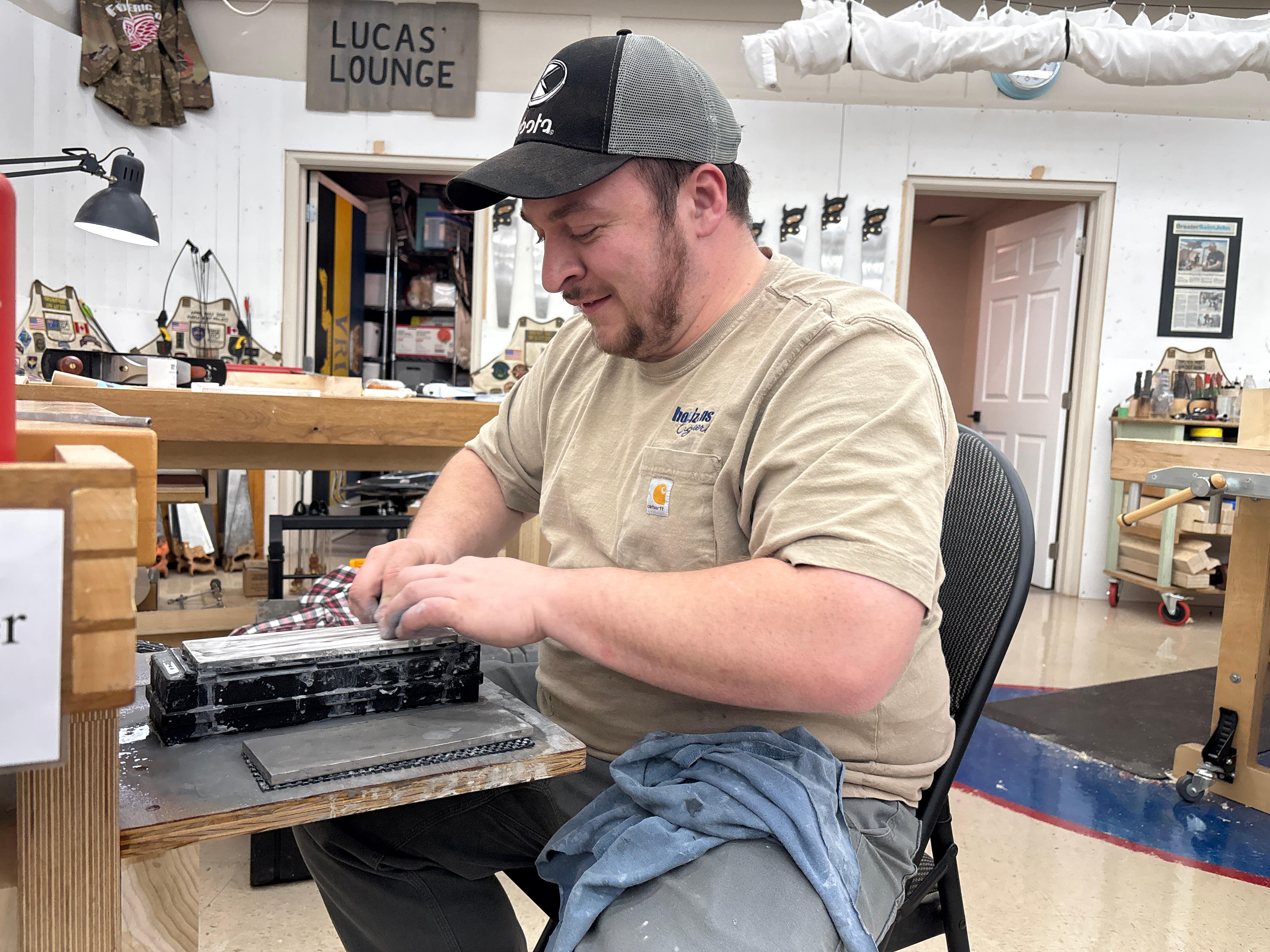 Man working on a project in a workshop with tools and equipment around.