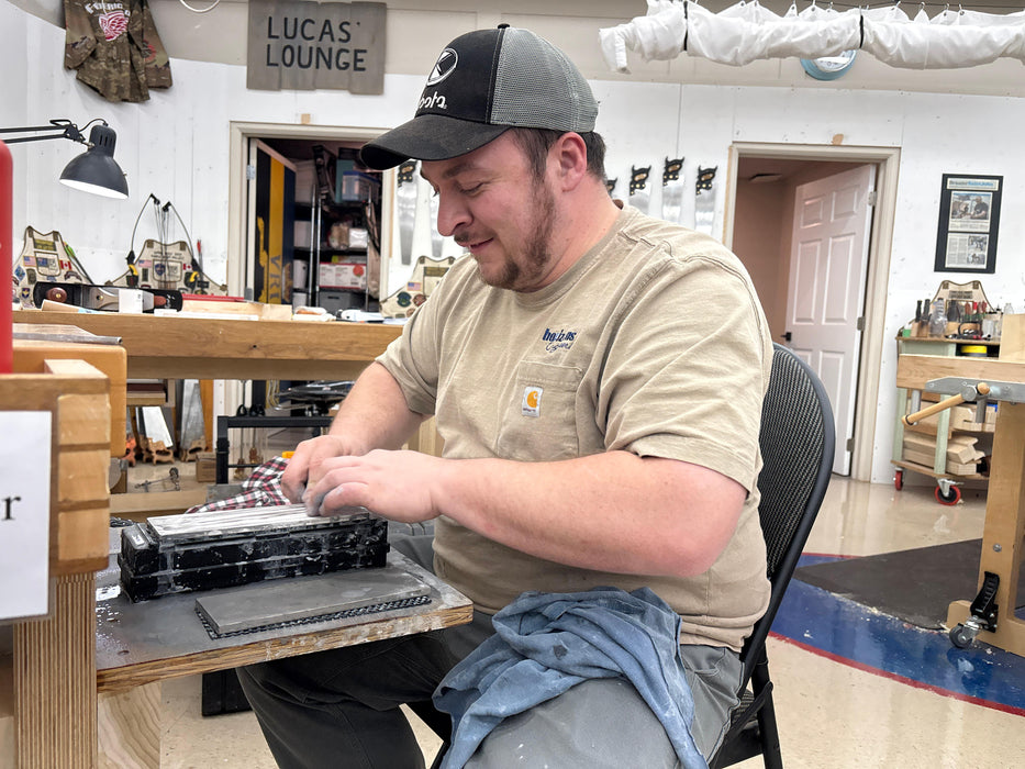Man working on a project in a workshop with tools and equipment around.