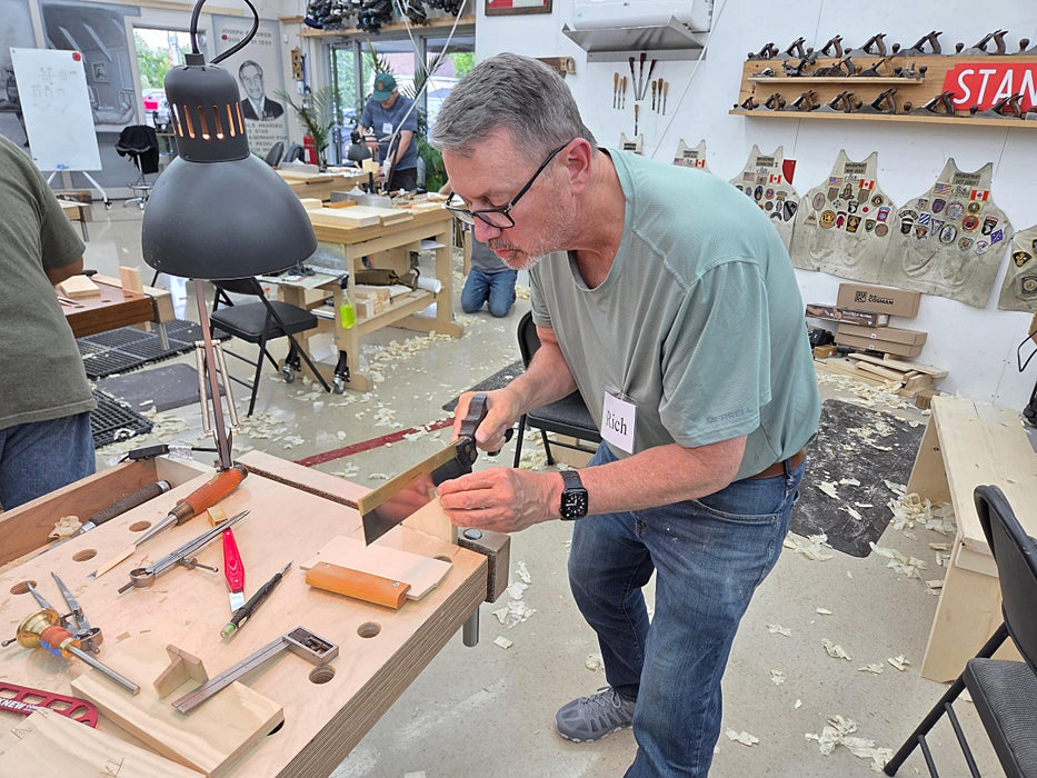 Man working on a project at a workbench in a workshop setting