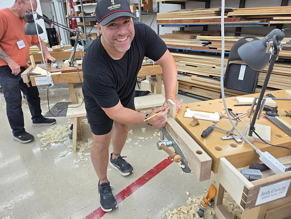Man working in a woodworking shop with tools and wood pieces around