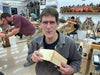 Man holding a wooden object in a workshop with 'Stanley' branding