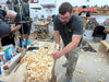 Man working with wood shavings in a workshop setting