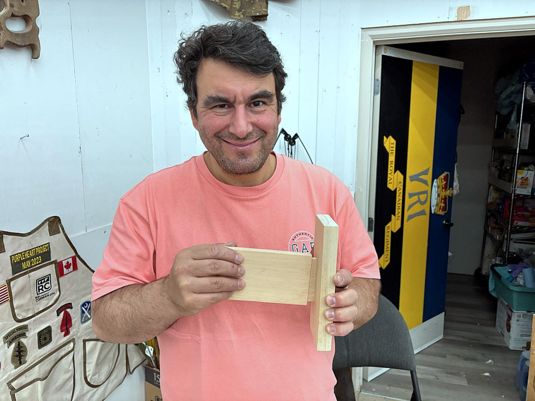 Man holding a wooden block in a workshop setting