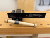 A close-up of a Rob Cosman Woodworking Vise, resting on a wooden workbench with a wooden-handle in front.