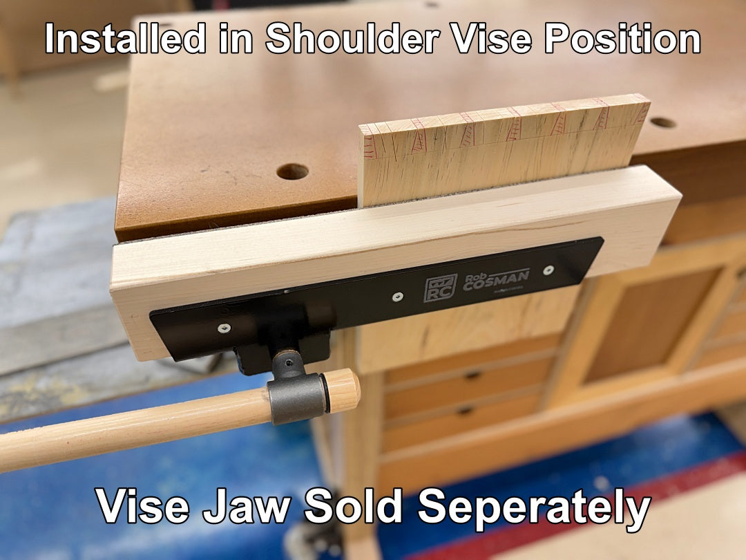 A close-up of a woodworking vise mounted on a workbench, with overlaid text reading 'Installed in Shoulder Vise Position' and 'Vise Jaw Sold Seperately.' The product appears to be the vise body and mounting hardware shown attached to the bench, photographed in a workshop setting.