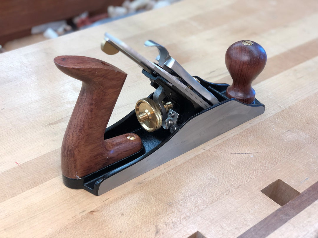 Wooden hand plane on a wooden surface