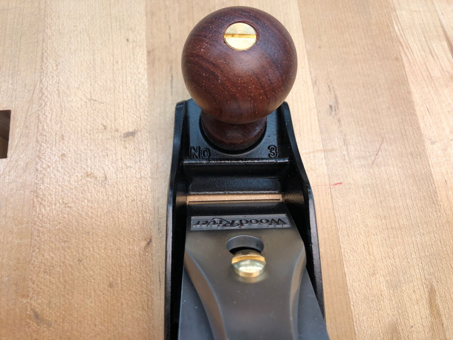 Wooden-handled plane tool on a wooden surface