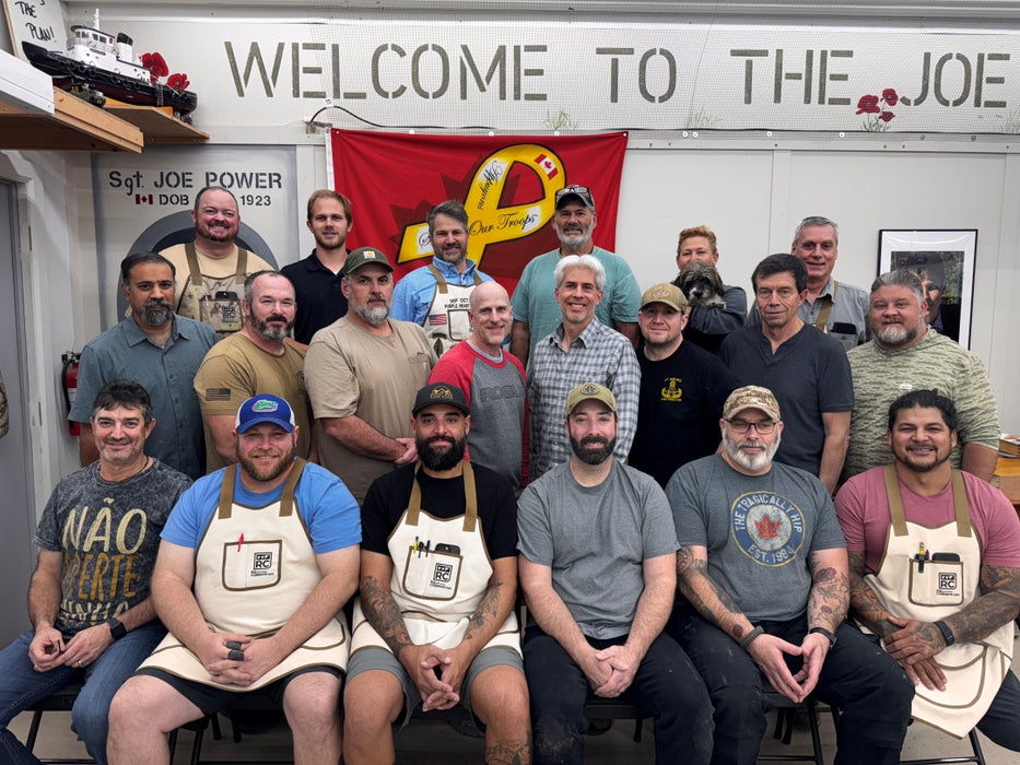 Group of men posing for a photo in front of a 'Welcome to The Joe' sign.