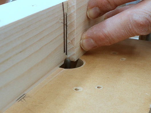 Rob Cosman using a whiteside router bit and his router table to cut a groove in a box side to accept the dowel for his woodhinge