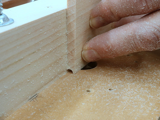 Rob Cosman using a whiteside router bit and his router table to cut a groove in a box side to accept the dowel for his woodhinge